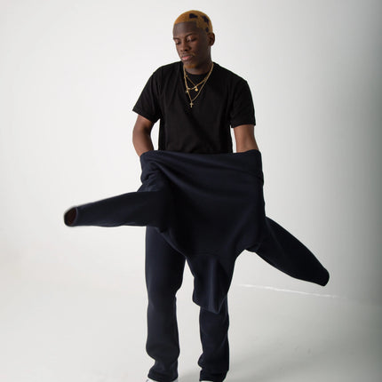 Fotografia de estúdio de um rapaz a tirar uma hoodie da WSYD, veste uma t-shirt preta da WSYDbasics